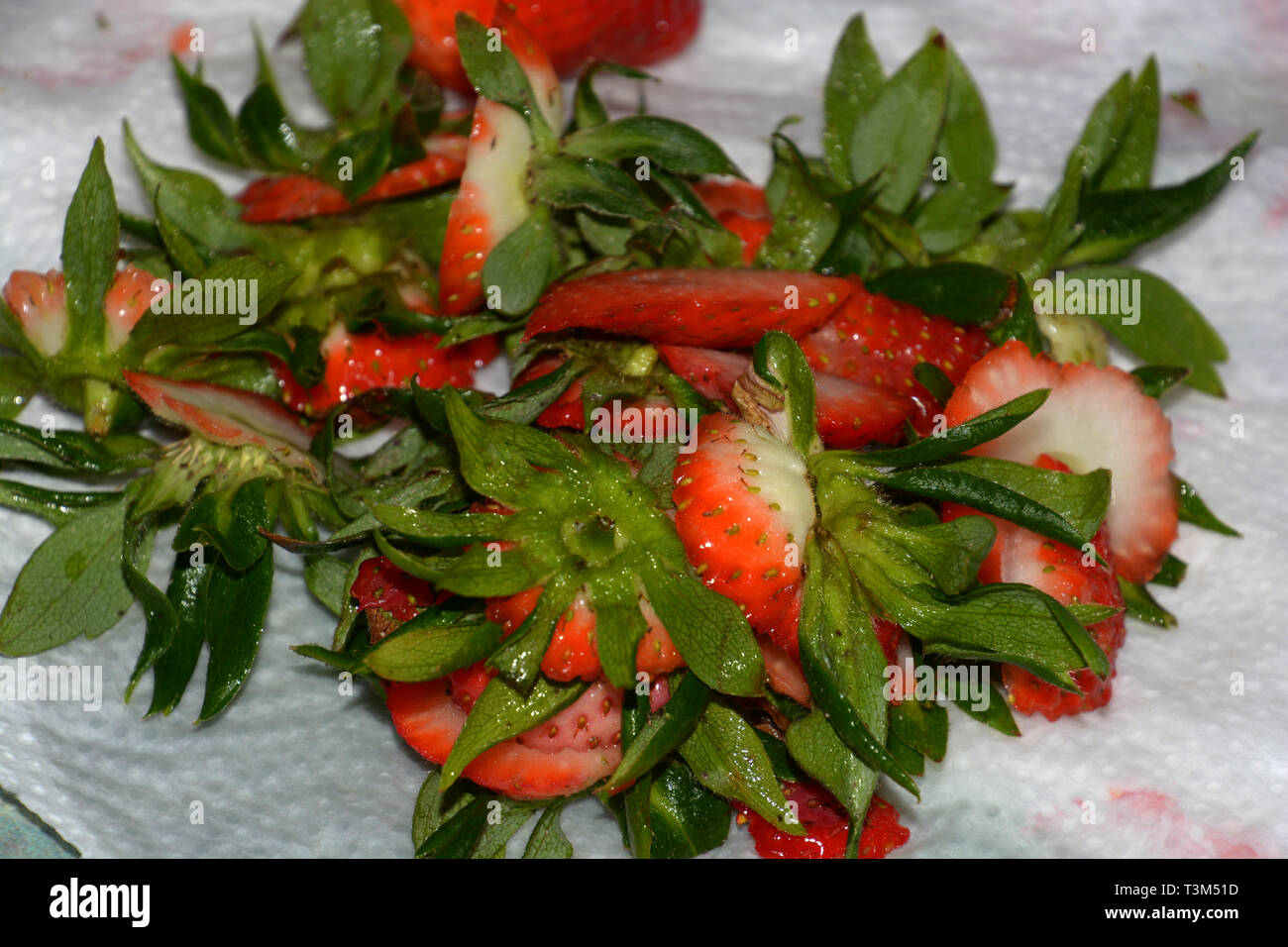 Kleine Haufen von Abfällen von Erdbeeren mit schlechten Spots nicht geeignet für zeitraubende, küchenabfälle der geschnittenen Erdbeeren auf einem weißen Küche papier Stockfoto