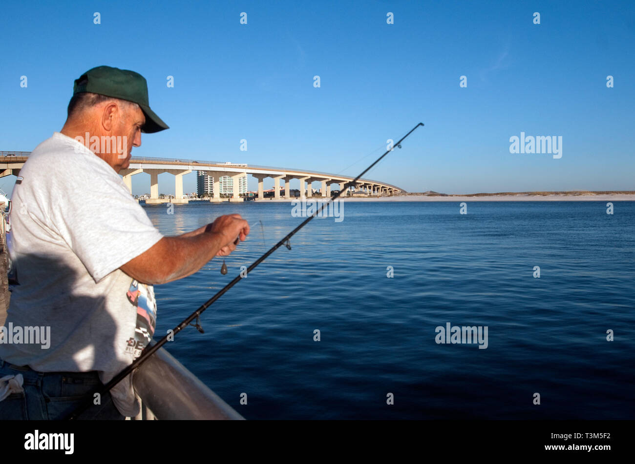 Ein Fischer Köder seine Haken an der Florida Punkt Fishing Pier, Nov. 12, 2009 in Orange Beach, Alabama. Stockfoto