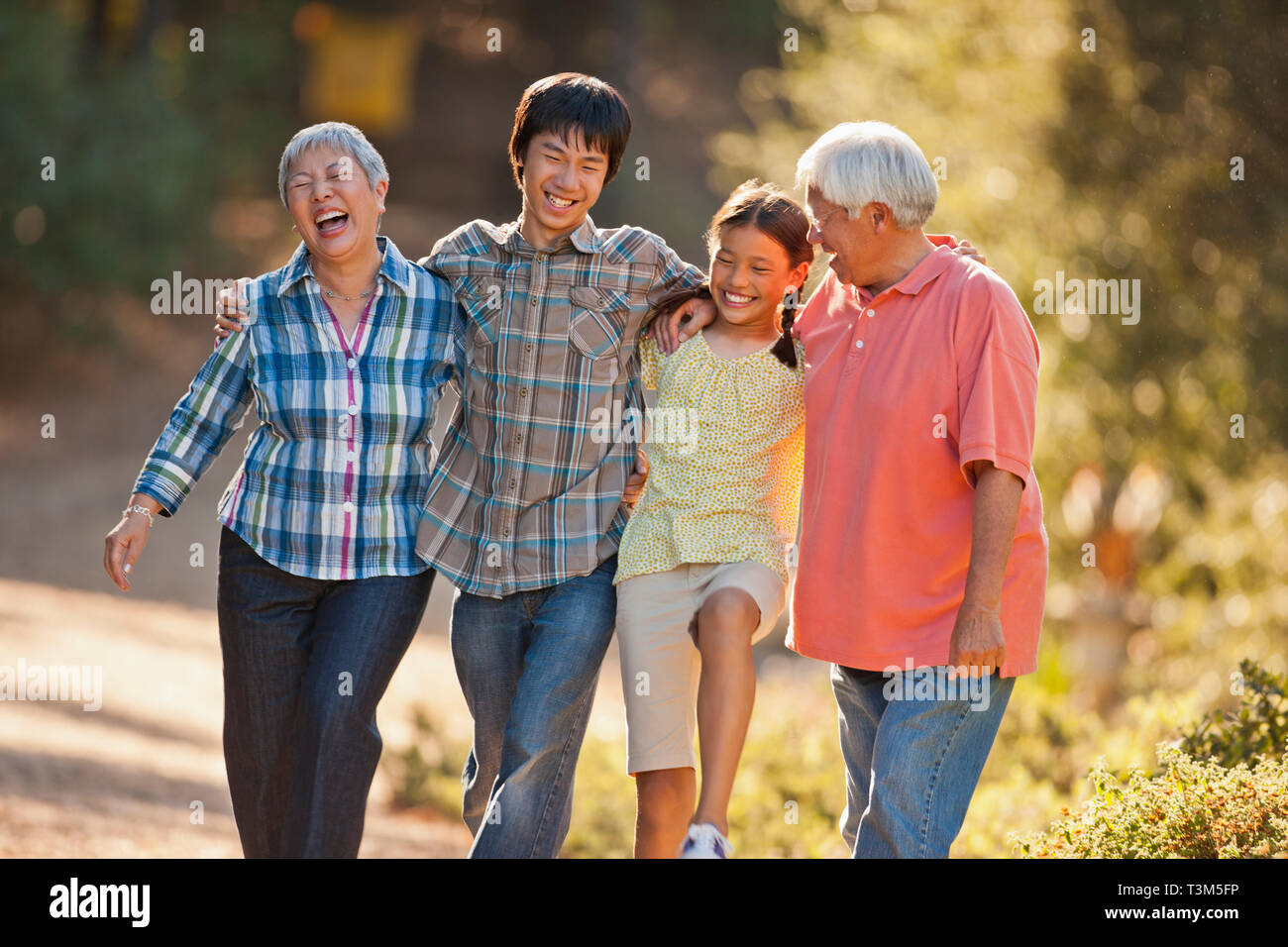 Lächelnd senior Paar Arm in Arm mit ihren Enkelkindern. Stockfoto