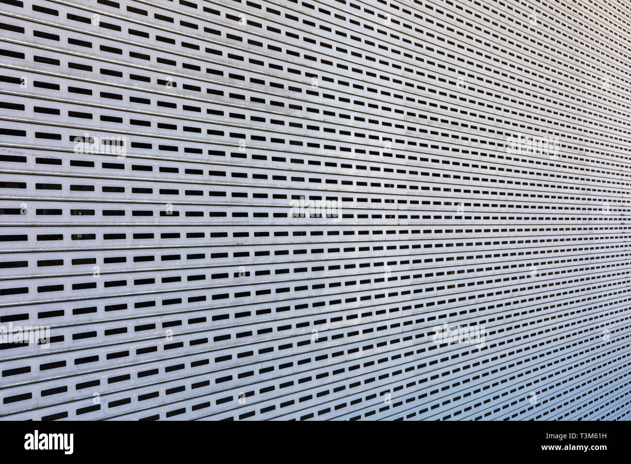Sich wiederholende durchbohrt Rechteckmuster auf Stahl, mit Perspektive Winkel fotografiert. Gut für industrielle oder modernen künstlerischen Hintergrund. Stockfoto