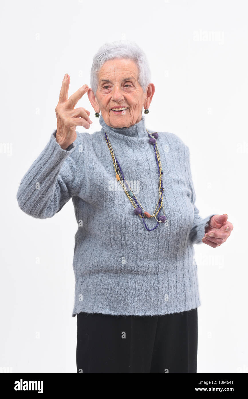 Ältere Frau, die den Sieg Zeichen auf weißem Hintergrund Stockfoto