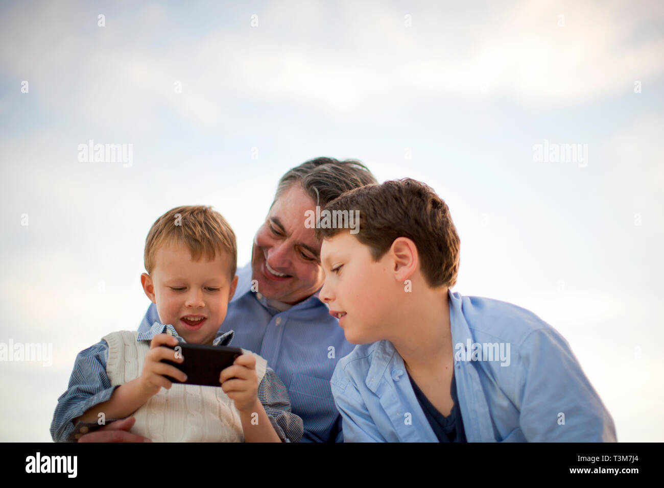 Junge spielt mit seinen Vätern iphone. Stockfoto