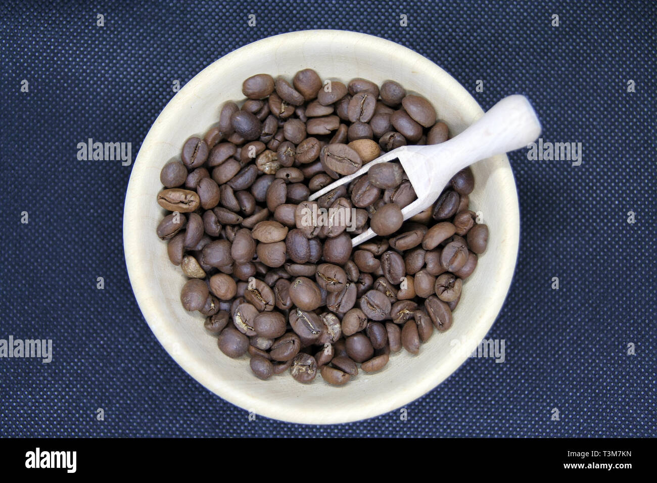 Kleine Schale aus Holz voll von gerösteten Kaffeebohnen. Geröstete Kaffeebohnen. Stockfoto