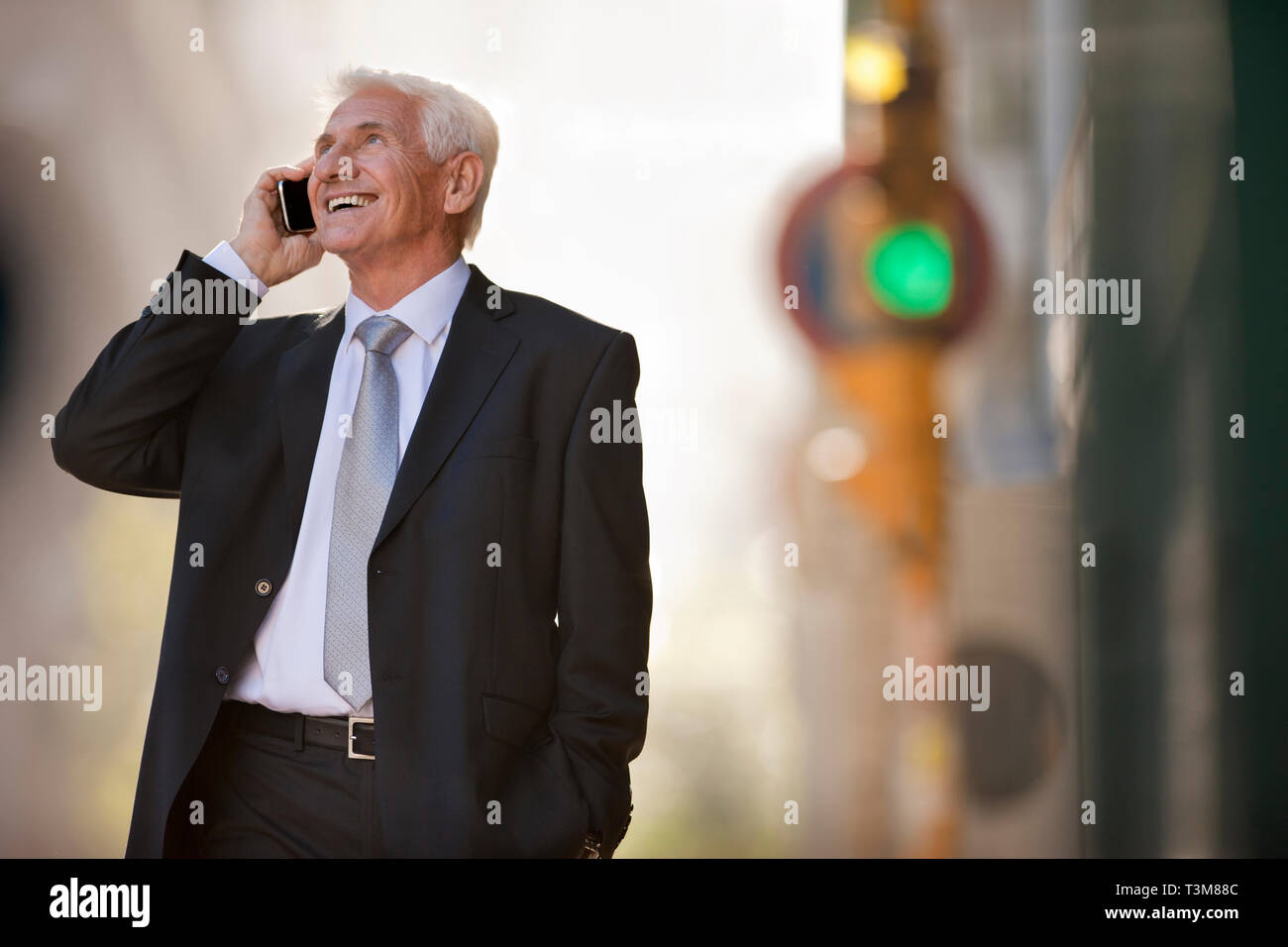 Reifen Geschäftsmann, Lächeln, als er einen Anruf auf einem Handy nimmt beim Stehen auf einer Straße der Stadt. Stockfoto