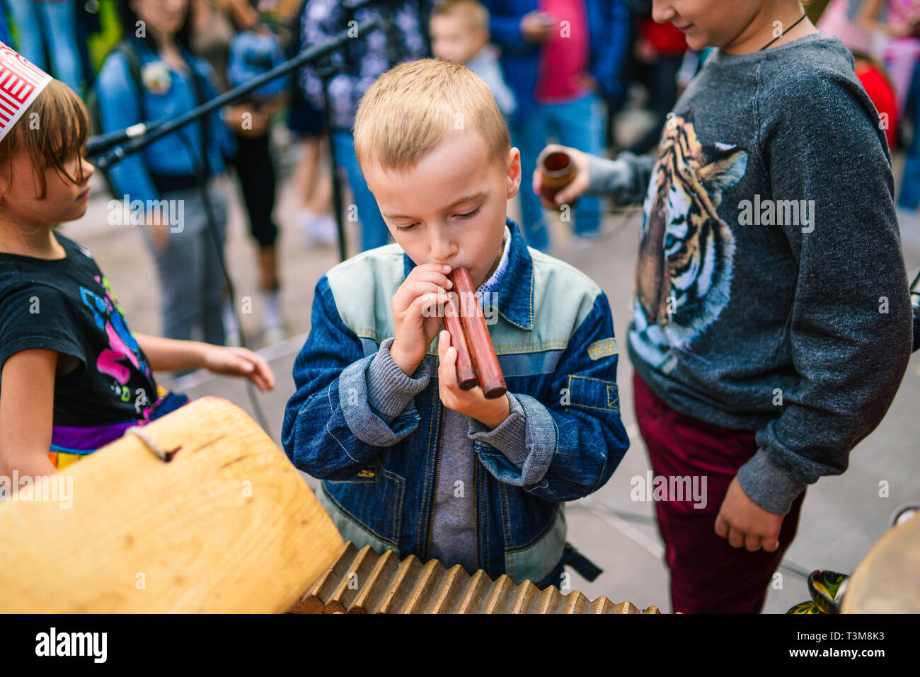 Russland, Stadt Moskau - September 6, 2014: Das Kind spielt ein Musikinstrument. Der Junge hält ein hölzernes tune in die Hände und spielt eine Melodie. Die Stockfoto