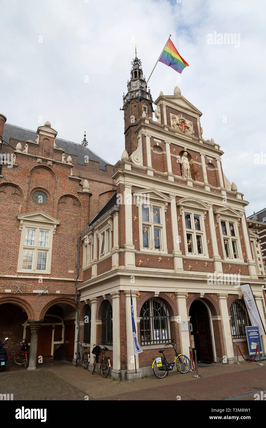 Der Regenbogen Flagge des LBGTQ Bewegung vor dem Rathaus in Haarlem, Niederlande fliegt. Es fliegt auf nationaler Coming Out Tag (11. Oktober). Stockfoto