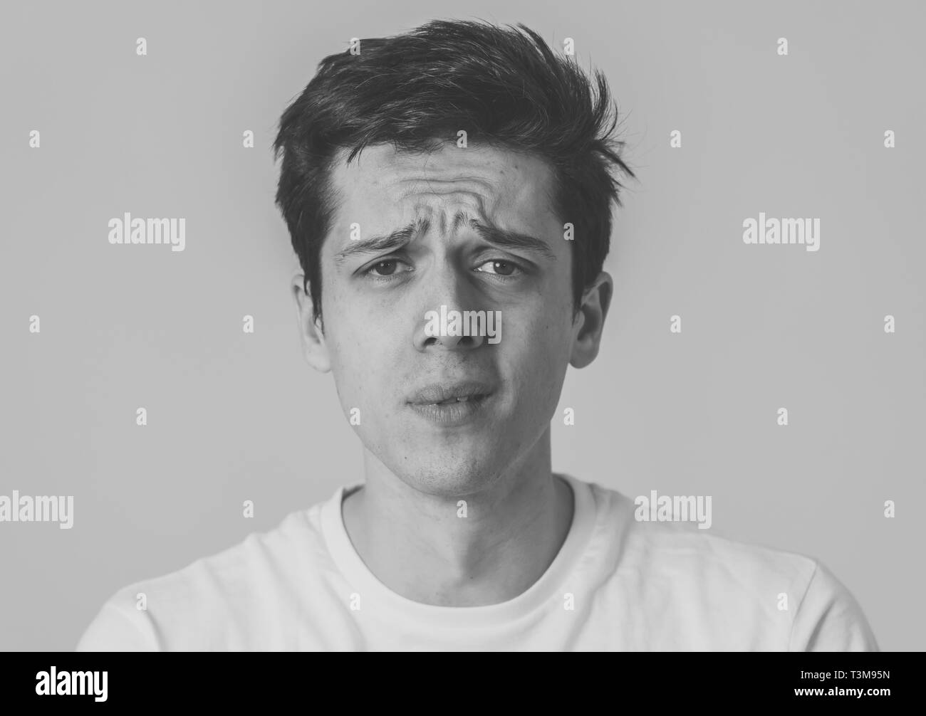 Schwarz-weiß-Porträt der jungen Mann traurig, ernst und besorgt, besorgt und nachdenklich. Gefühl Trauer und Depression. Mit kopieren. In f Stockfoto
