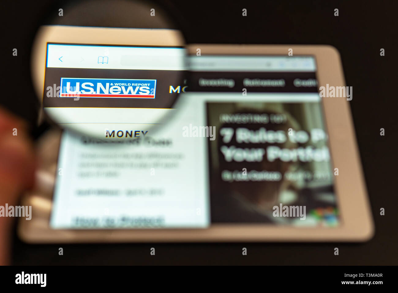Uns News Channel Logo sichtbar durch ein Vergrößerungsglas. Kann wie Marketing oder Business Konzept verwendet werden. Nachrichten Web site homepage auf dem Tablet Stockfoto
