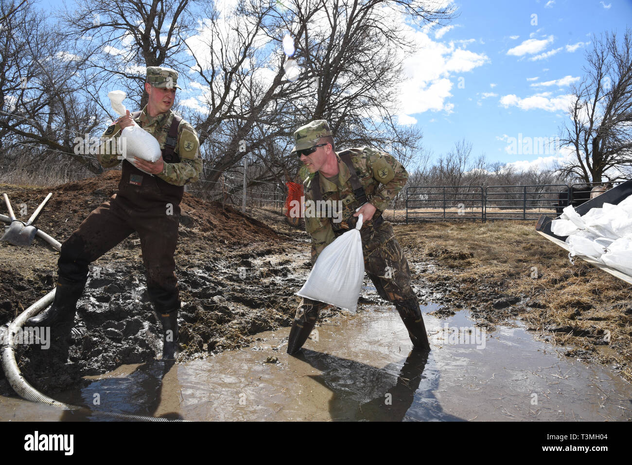 North Dakota Armee Nationalgarde stand in Hochwasser, wie sie Sandsäcke steigende floodwater von der Sicherung durch ein Abfluss Kanal in einem Bauernhof im ländlichen Cass County April 8, 2019 in der Nähe von West Grand Forks, North Dakota zu Block platzieren. Der Datensatz Hochwasser soll als späten winter storm Fässer in den Mittleren Westen der USA in den nächsten Tagen verschlechtern. Stockfoto