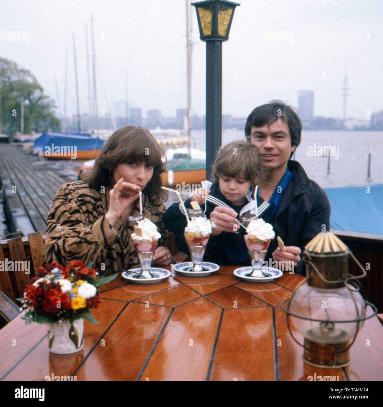 Deutscher Komponist, Sänger und Gitarrist Henner Hoier beim Eis essen mit Frau und Tochter an der Alster, Hamburg Deutschland Ca. 1980er. Deutsche Komponist, Sänger und Gitarrist Henner Hoier Eis essen mit Frau und Tochter an der Alster, Hamburg Deutschland Ca. 80er Jahre. Stockfoto