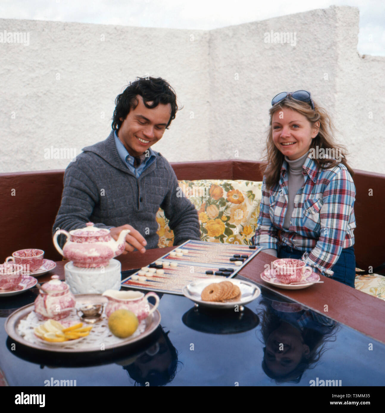 Deutscher Komponist, Sänger und Gitarrist Henner Hoier mit Freundin beim Backgammon spielen im türkeirundreise, Ca. 1980er. Deutsche Komponist, Sänger und Gitarrist Henner Hoier Backgammon spielen mit einer freundin im sommer urlaub, Ca. 80er Jahre. Stockfoto