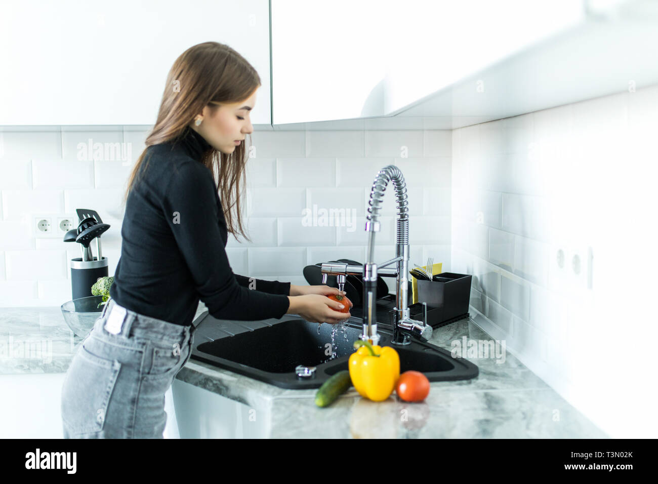 Die Frau Hände Waschen von Gemüse im Spülbecken in der Küche Stockfoto