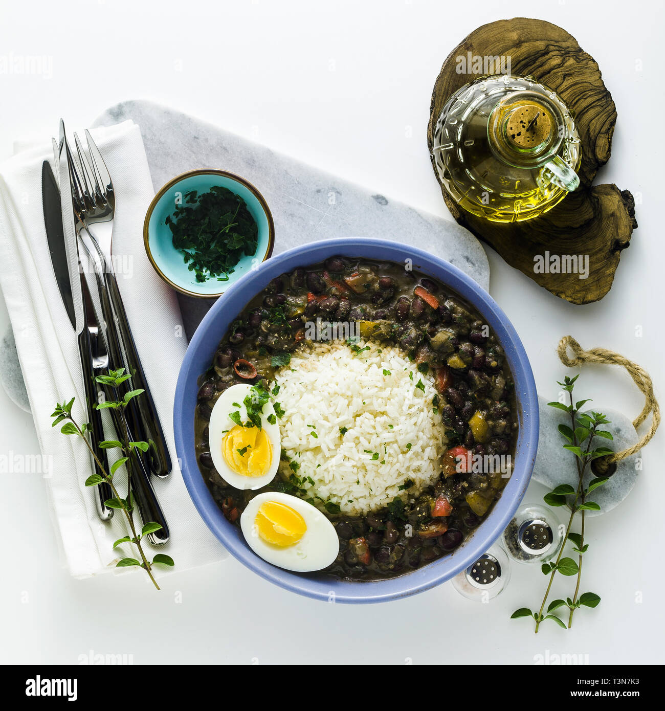 Reis mit schwarzen Bohnen und gekochtes Ei auf den Tisch mit Gewürzen und Olivenöl. Gesunde karibisches Essen Stockfoto