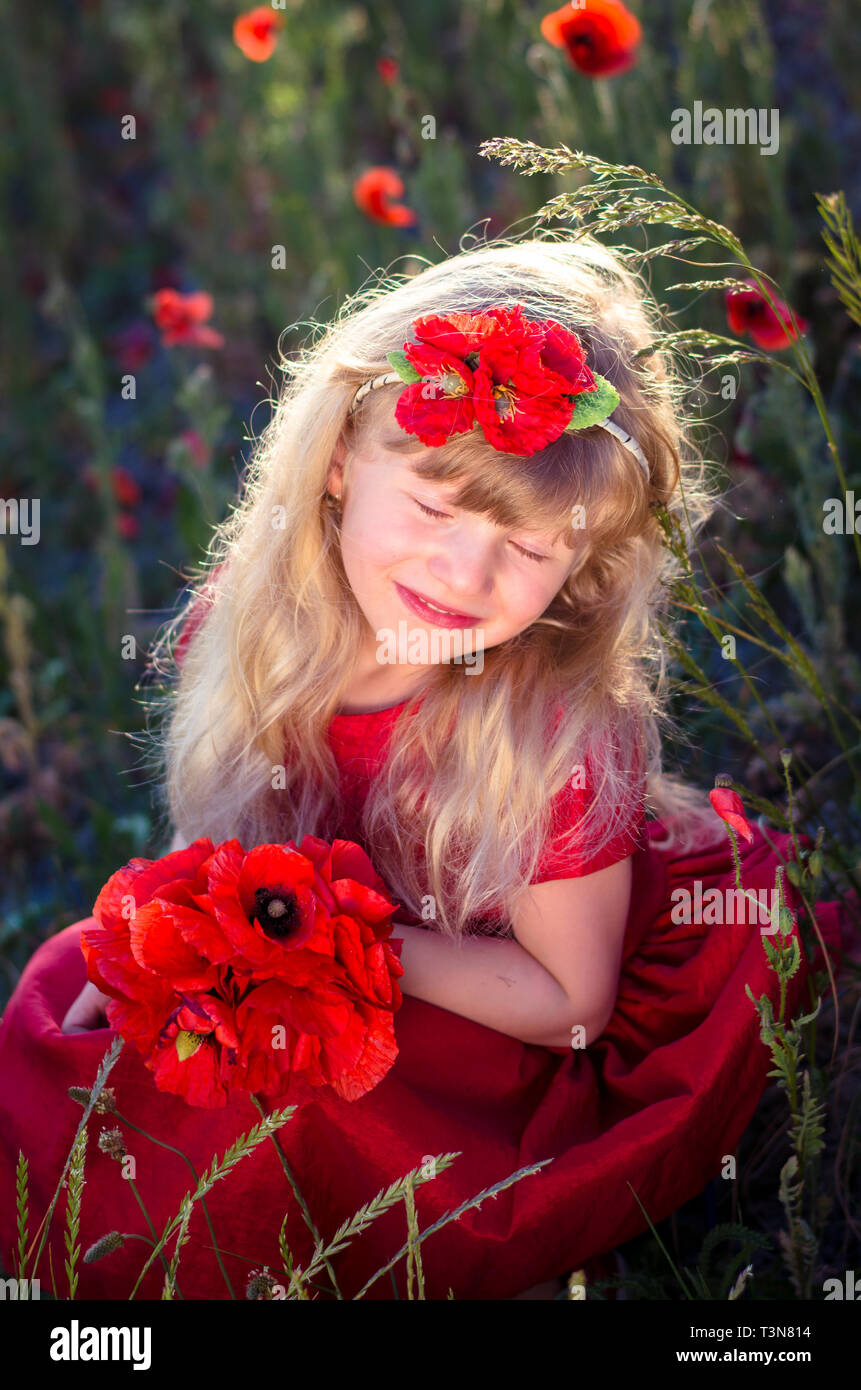 Schöne blonde Mädchen mit roten Corn Poppy Flower Stockfoto