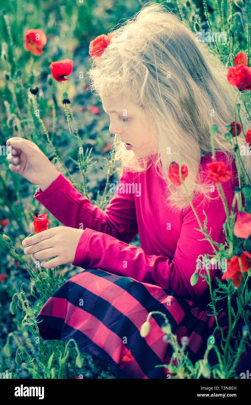 Schöne blonde Mädchen mit roten Corn Poppy Flower Stockfoto