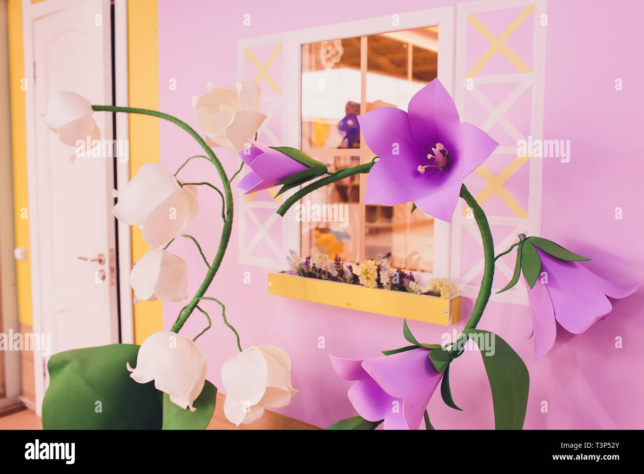 Papier Blumen und Wellpappe auf der Wand Stockfoto