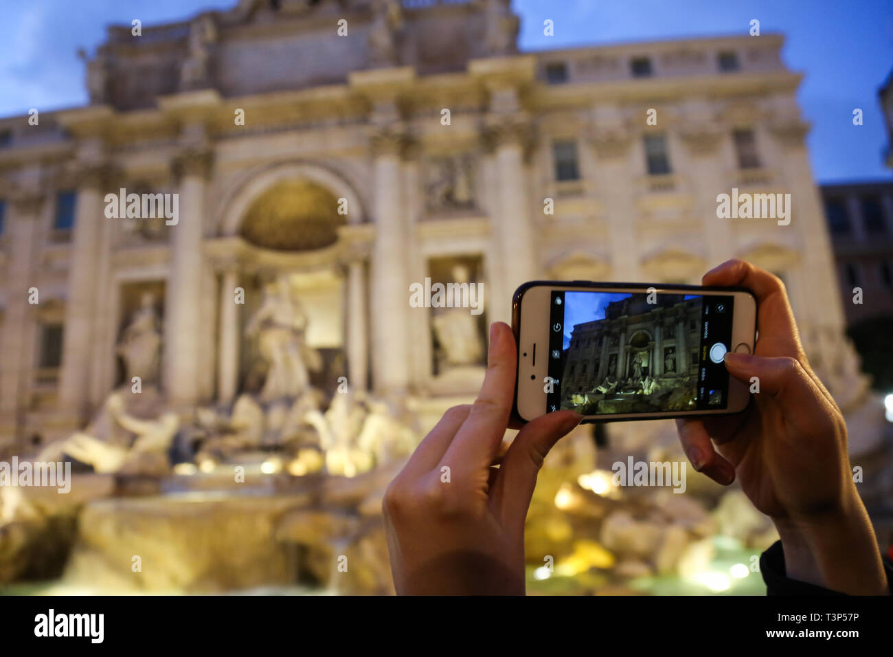 Eine Person nimmt ein Bild von dem Trevi Brunnen auf ihrem Mobiltelefon in Rom, Italien Stockfoto