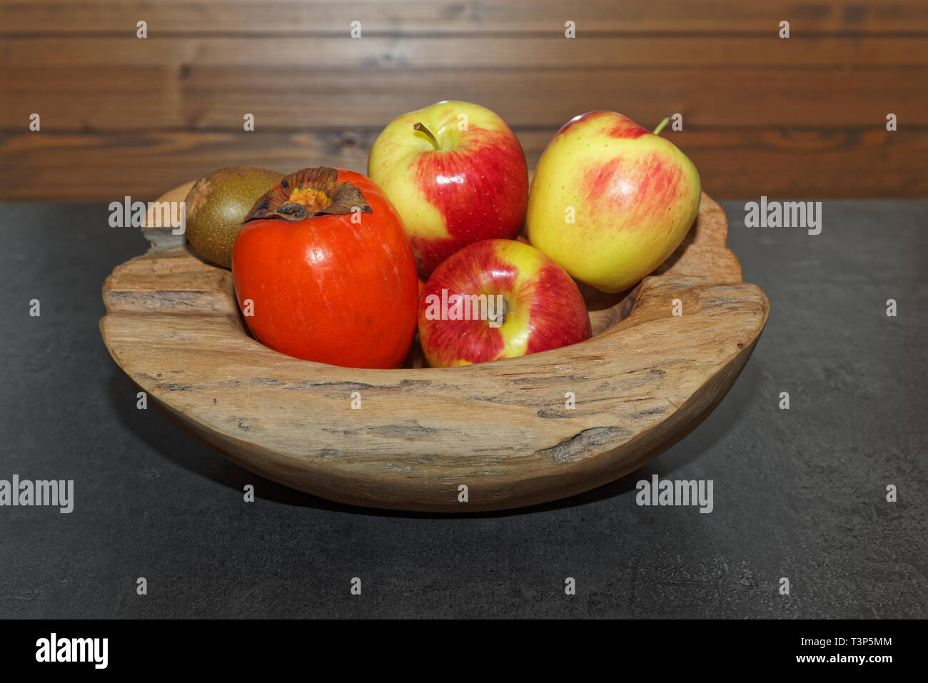Szene der Früchte in eine hölzerne Schüssel auf dunklen Tisch. Torfhaus, Deutschland Stockfoto