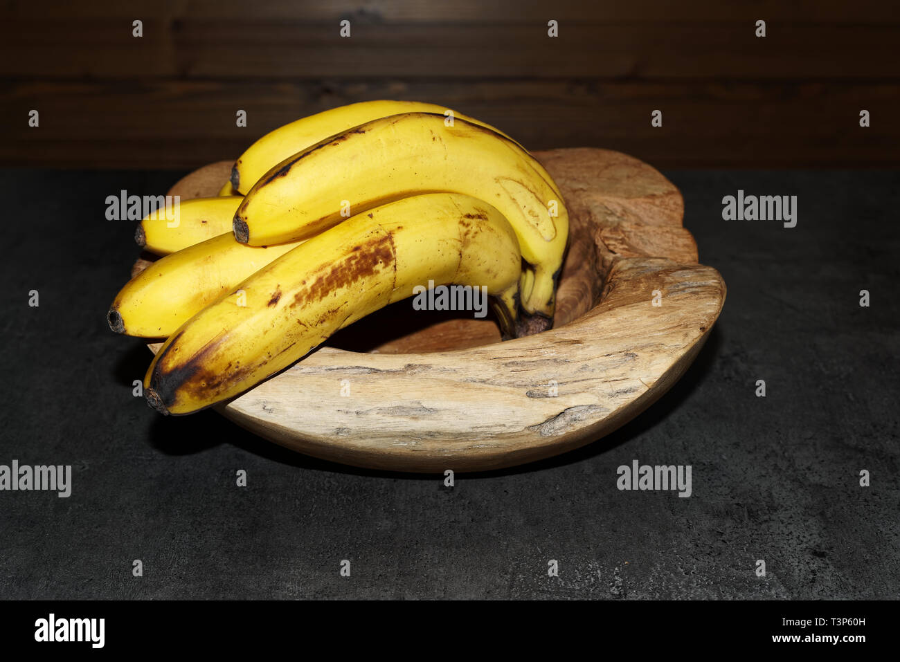 Gelbe Bananen in eine hölzerne Schüssel Reif. Torfhaus, Deutschland Stockfoto
