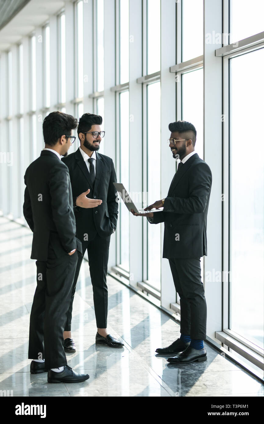 Die Silhouetten der drei asiatischen Führungskräfte stehen vor Windows Diskussion von mit Laptop Computer. Stockfoto