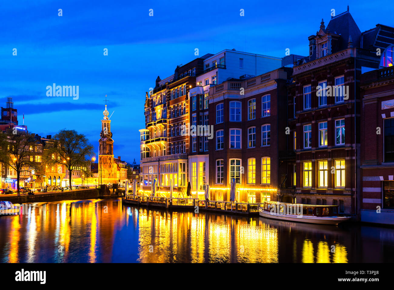Nacht-Stadtansicht von Amsterdam in den Niederlanden mit Fluss Amstel Stockfoto
