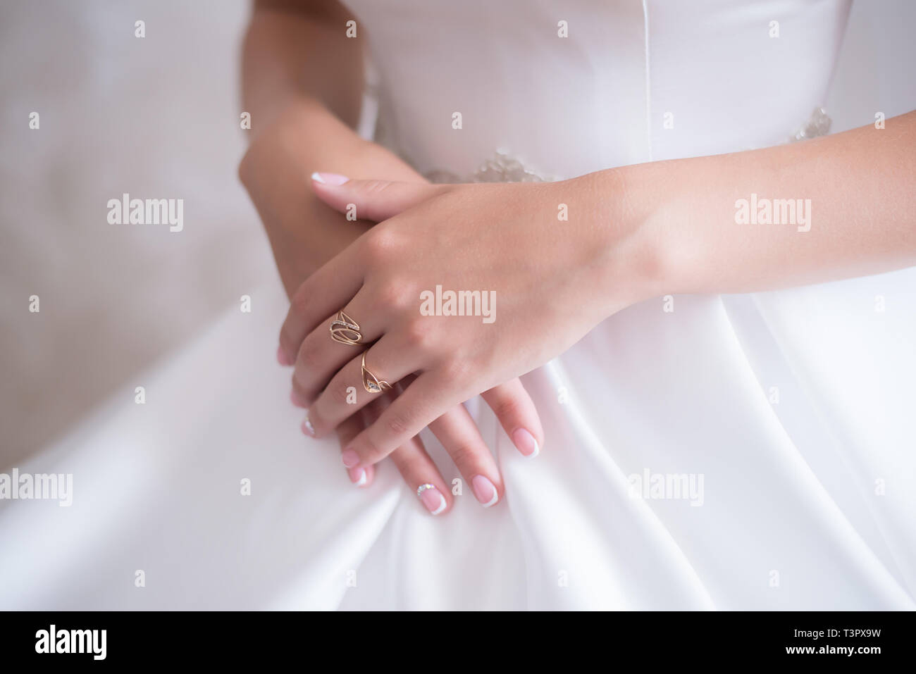 Junge Braut im Brautkleid vorsichtig mit den Fingern halten ihre Hände mit einem Ring Stockfoto
