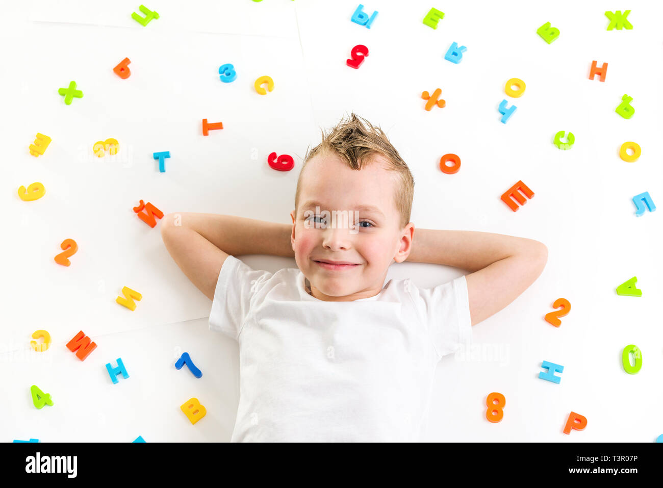 Lächelnde Junge lag auf dem Boden Stockfoto