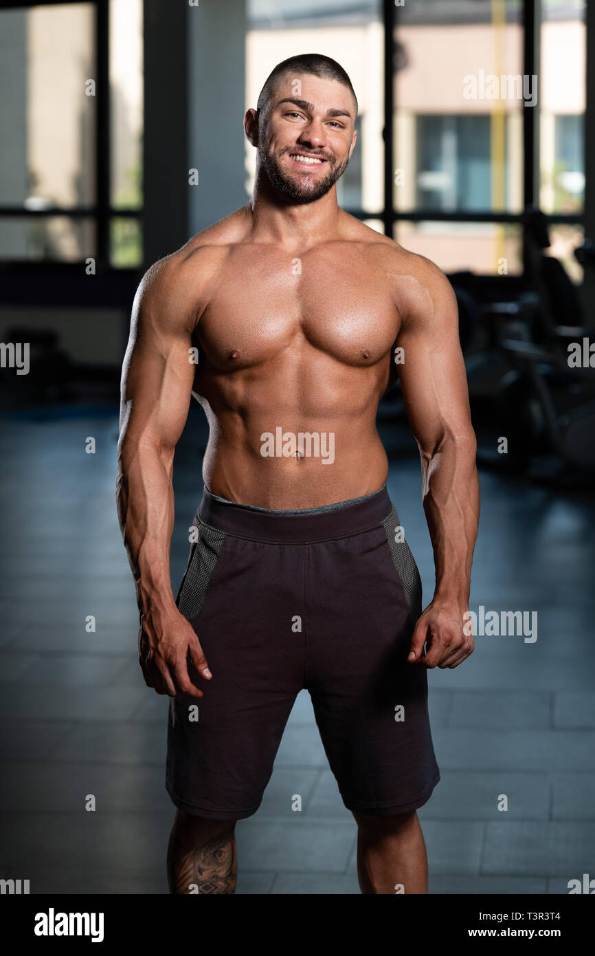 Junger Mann standhaft In der Turnhalle und biegen Muskeln - muskulöse  athletische Bodybuilder Fitness Model posiert nach Übungen Stockfotografie  - Alamy
