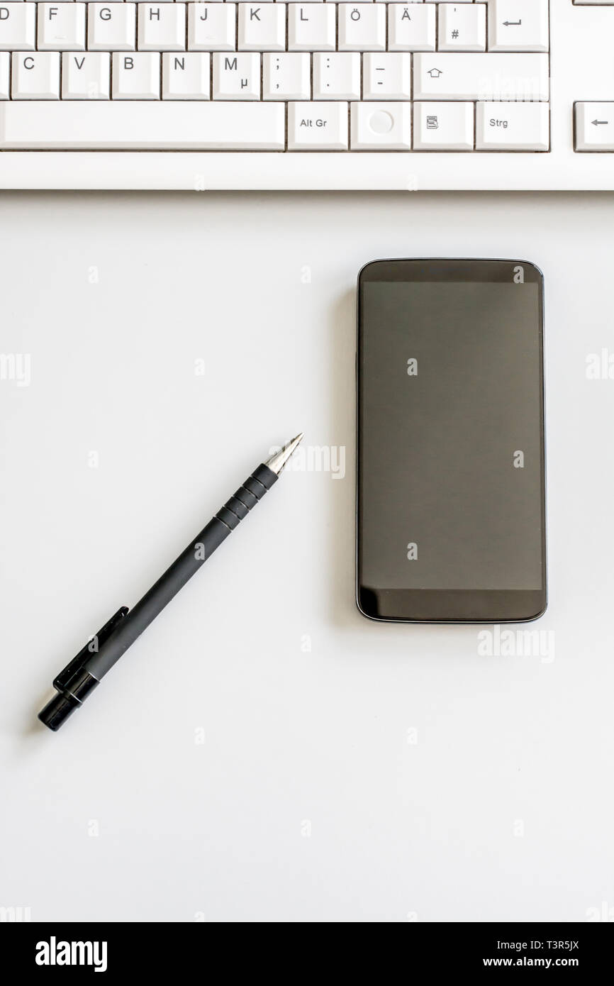 Für einen aufgeräumten Schreibtisch mit Smartphone, Pen und Computer Tastatur von oben fotografiert Stockfoto