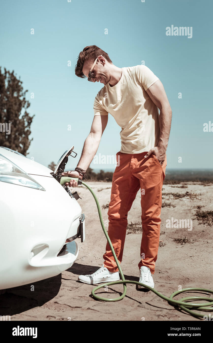 Freudige brunette männliche Person an seinem Auto suchen Stockfoto Freudige brunette männliche Person an seinem Auto suchen Stockfoto