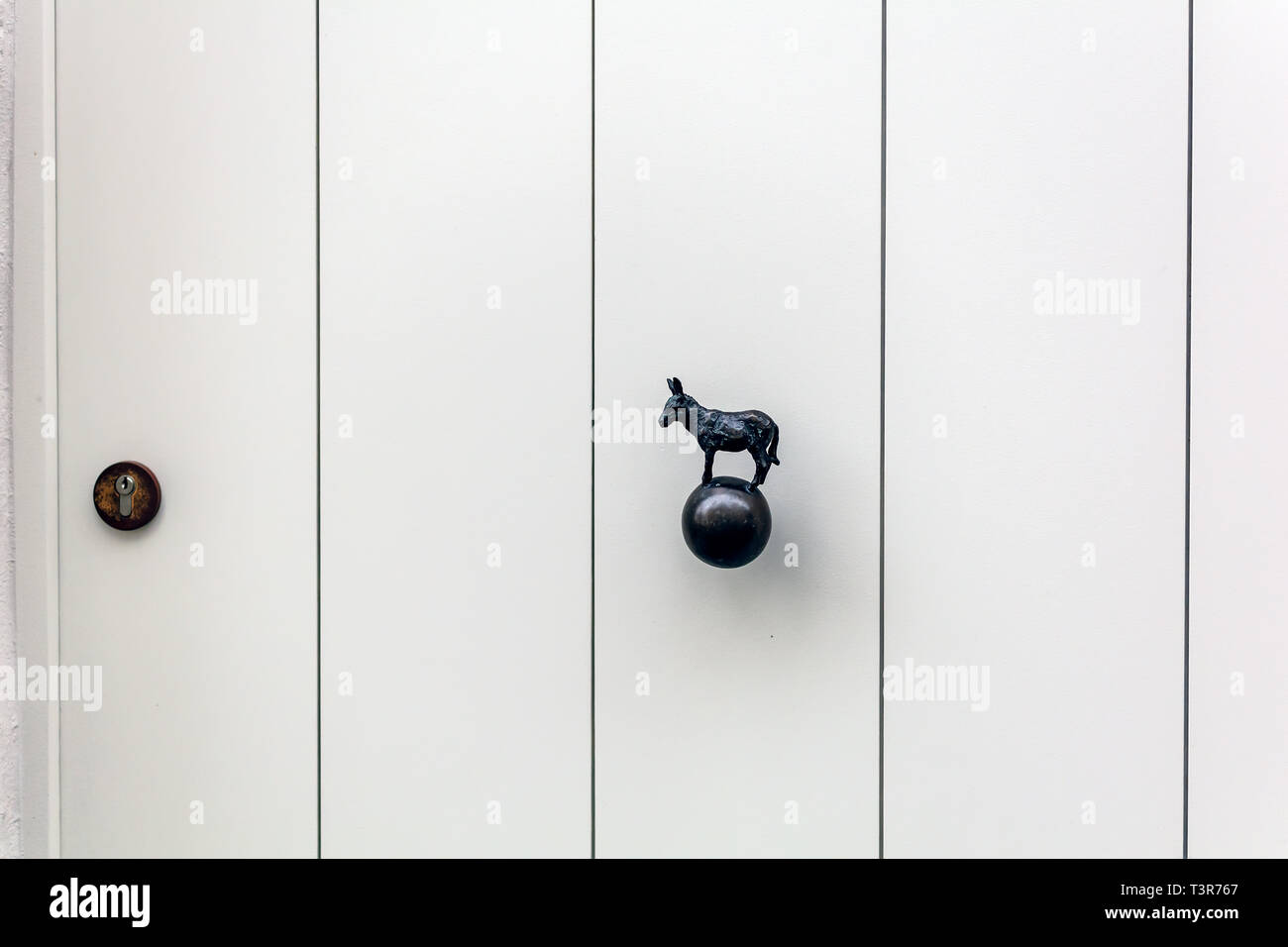 Scharf weiße Holztür mit Esel geformte Messing Türknopf oder in einem der mittelalterlichen Stadt Brügge Häuser in Belgien. Vintage dekorative Türgriff Stockfoto