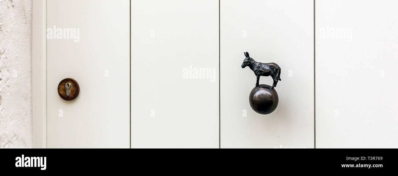 Scharf weiße Holztür mit Esel geformte Messing Türknopf oder in einem der mittelalterlichen Stadt Brügge Häuser in Belgien. Vintage dekorative Türgriff Stockfoto