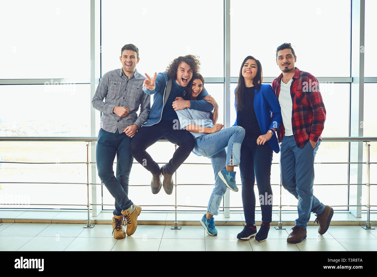 Junge Menschen stehen gegen das Fenster Stockfoto