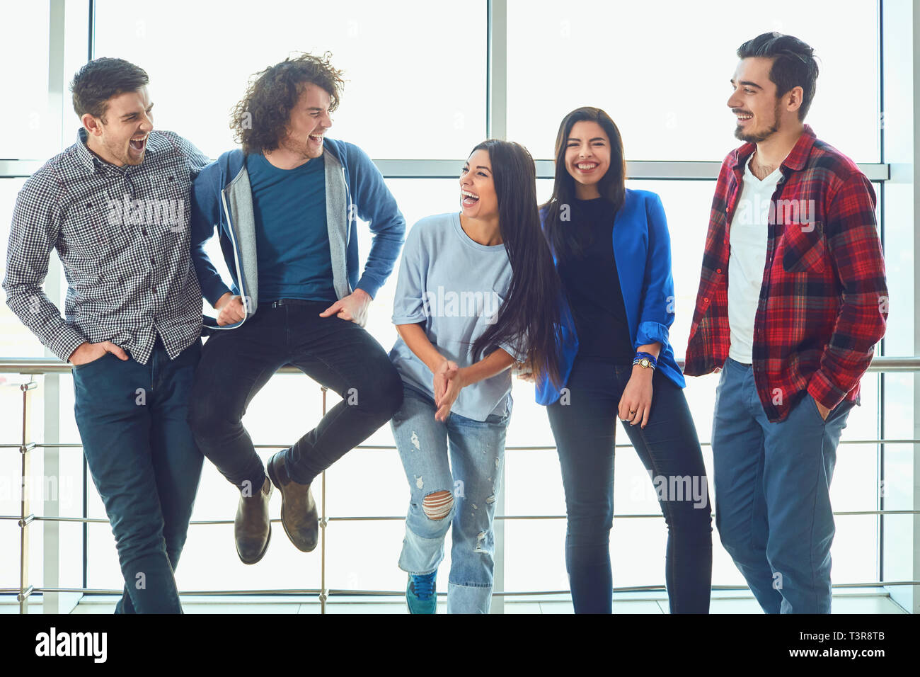 Junge Menschen stehen gegen das Fenster Stockfoto