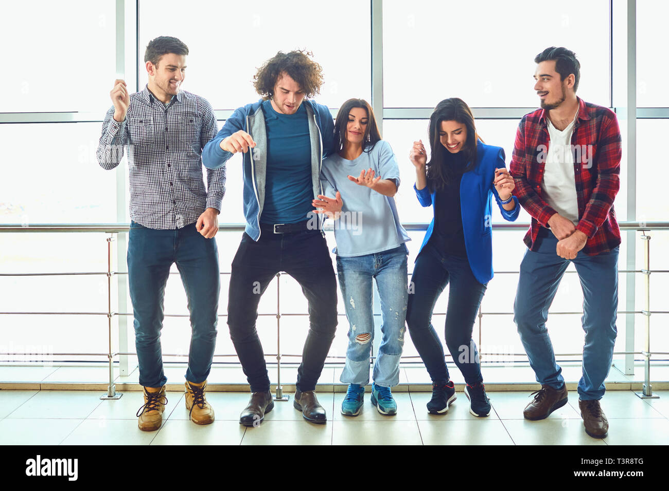 Junge Menschen stehen gegen das Fenster Stockfoto