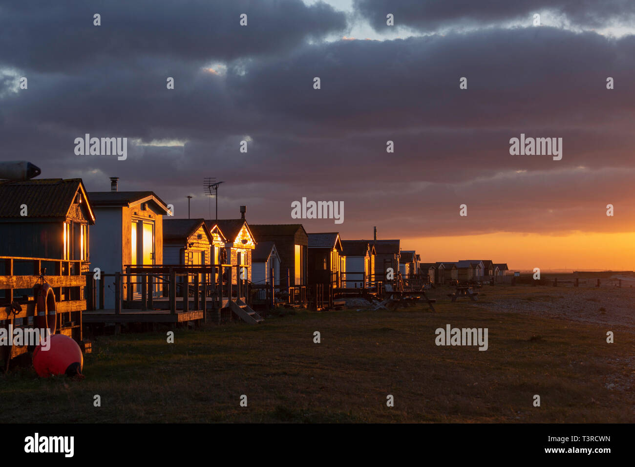 Licht Sonnenuntergang am Strand Hütten am Seasalter, Whitstable, Kent GROSSBRITANNIEN. Während April getroffen. Stockfoto