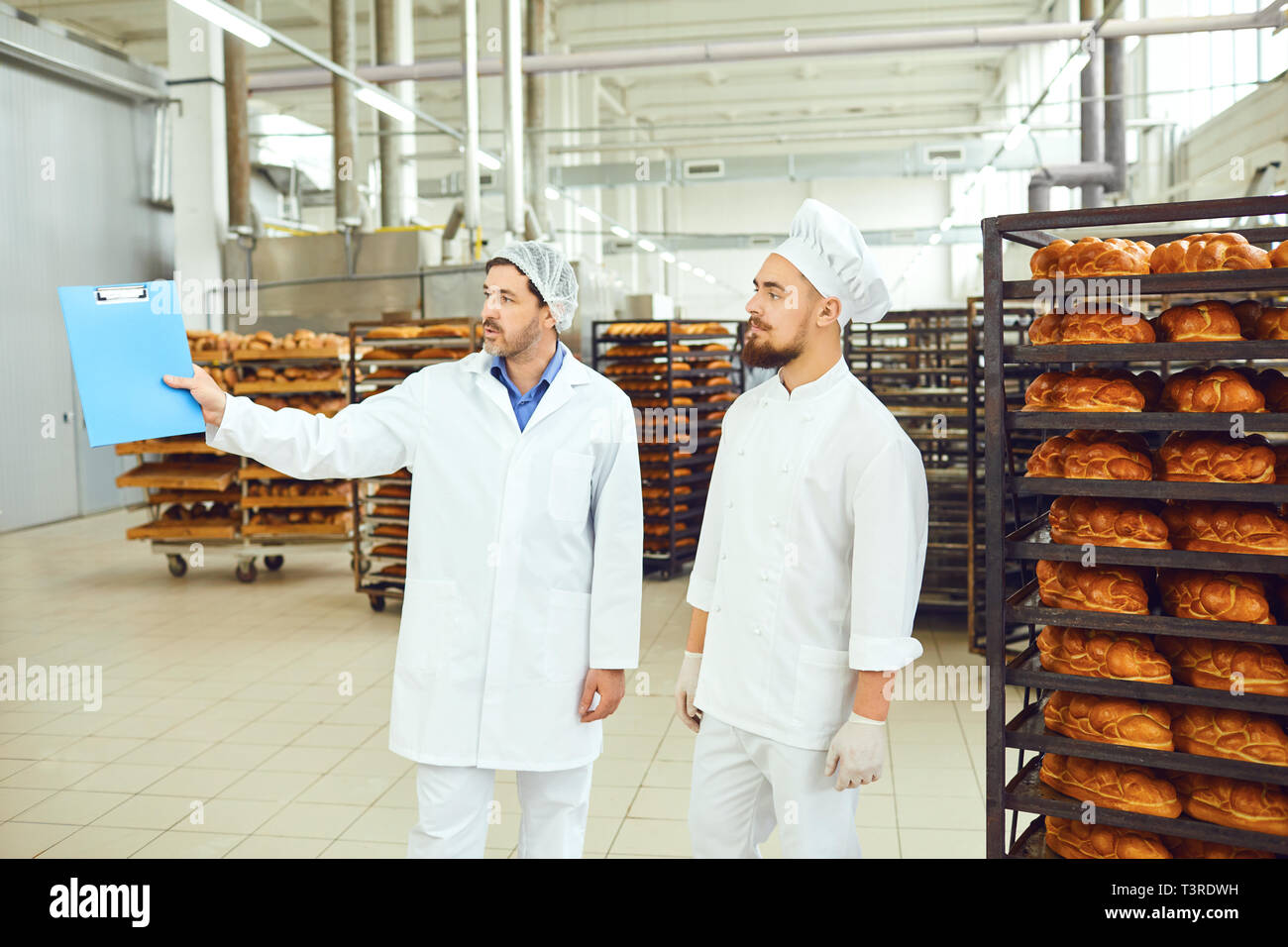 Der Technologe und Baker sprechen in einer Brotfabrik. Stockfoto