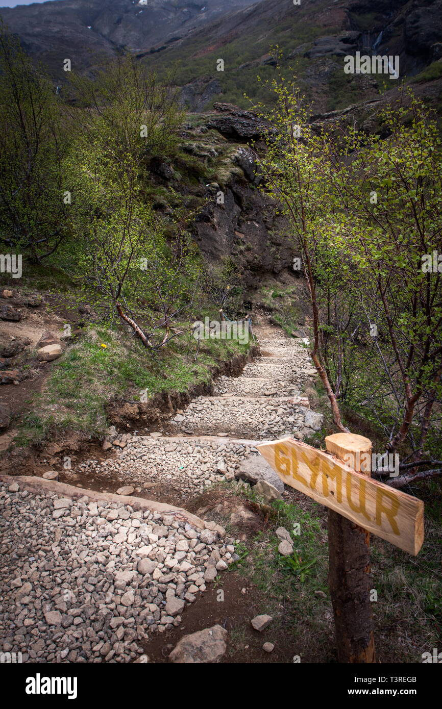 Schöne Landschaft mit einem Schild auf der Treppe unter der Vegetation, die zu den Wasserfall - Glymur, Island Stockfoto