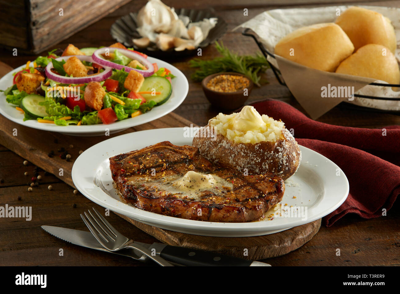 Kanas City Knochen in Strip Steak mit Baked Potato, Salat, und Abendessen Brötchen Stockfoto