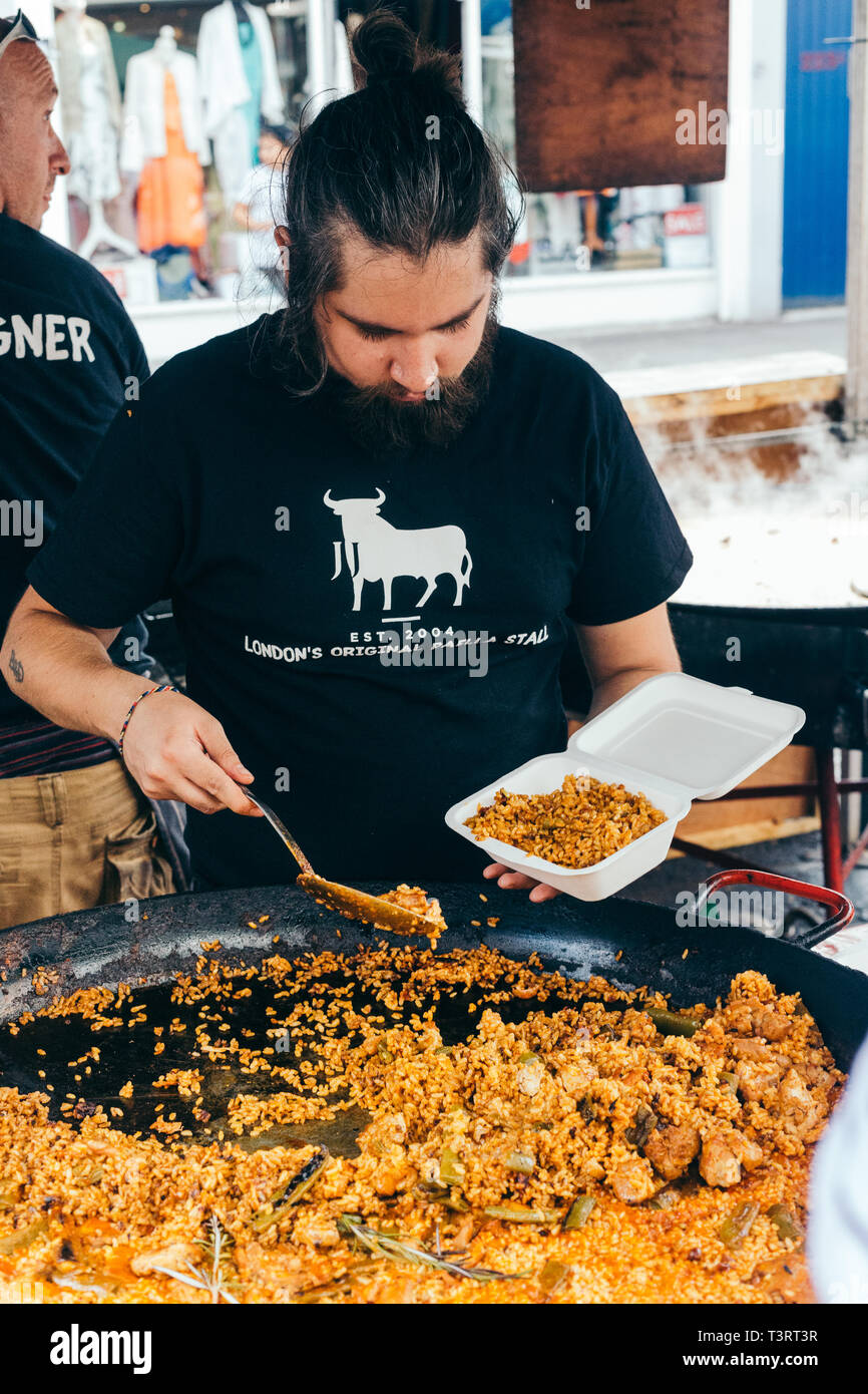 London/Großbritannien - 20. Juli 2018: Mann kochen Paella an der Portobello Market in Notting Hill. Eine von Londons bemerkenswerte Straßenmärkte, bekannt für seine zweite Hand c Stockfoto