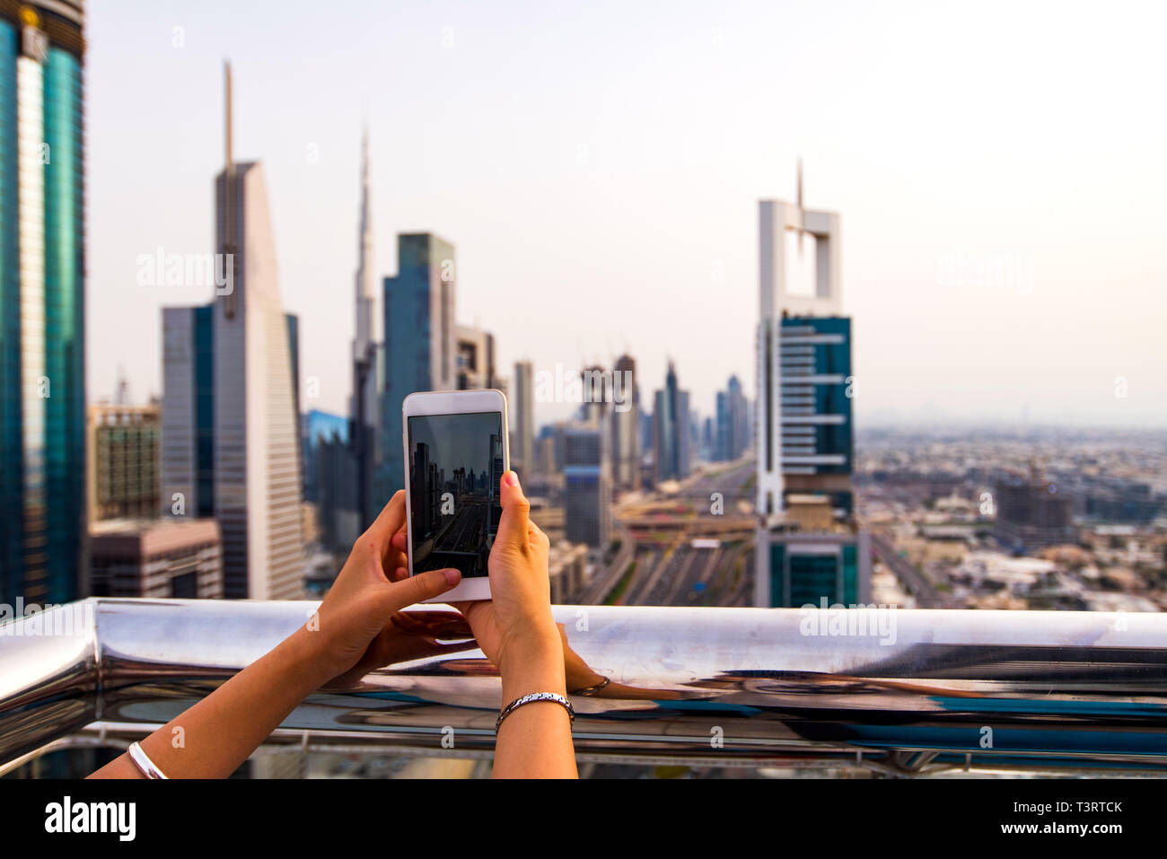 Frau unter Foto von Dubai Stadtbild per Telefon Stockfoto