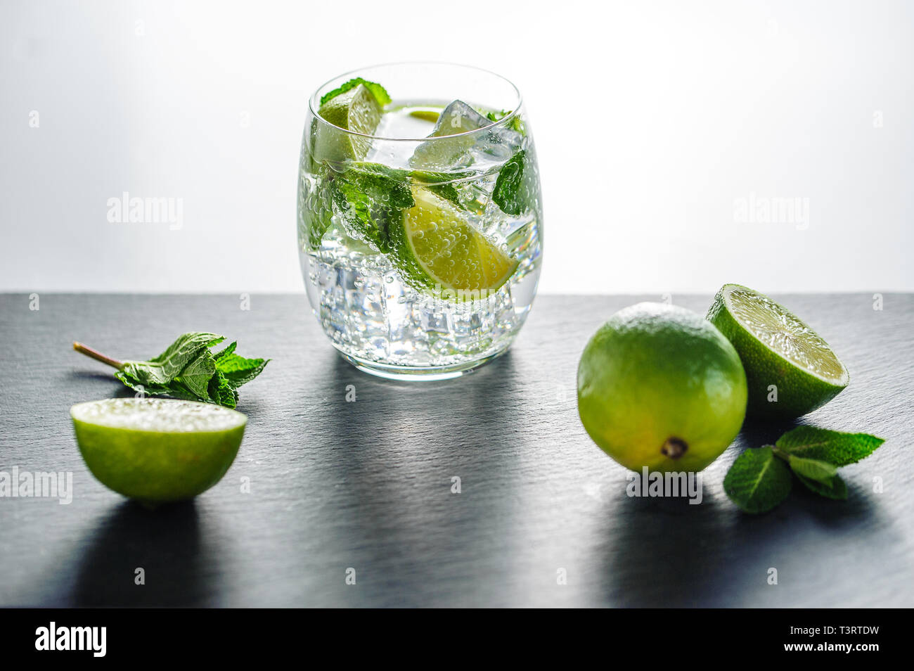 Sommer cocktail Konzept: frischen Mojito auf Schneidebrett mit grünem Limes Stockfoto