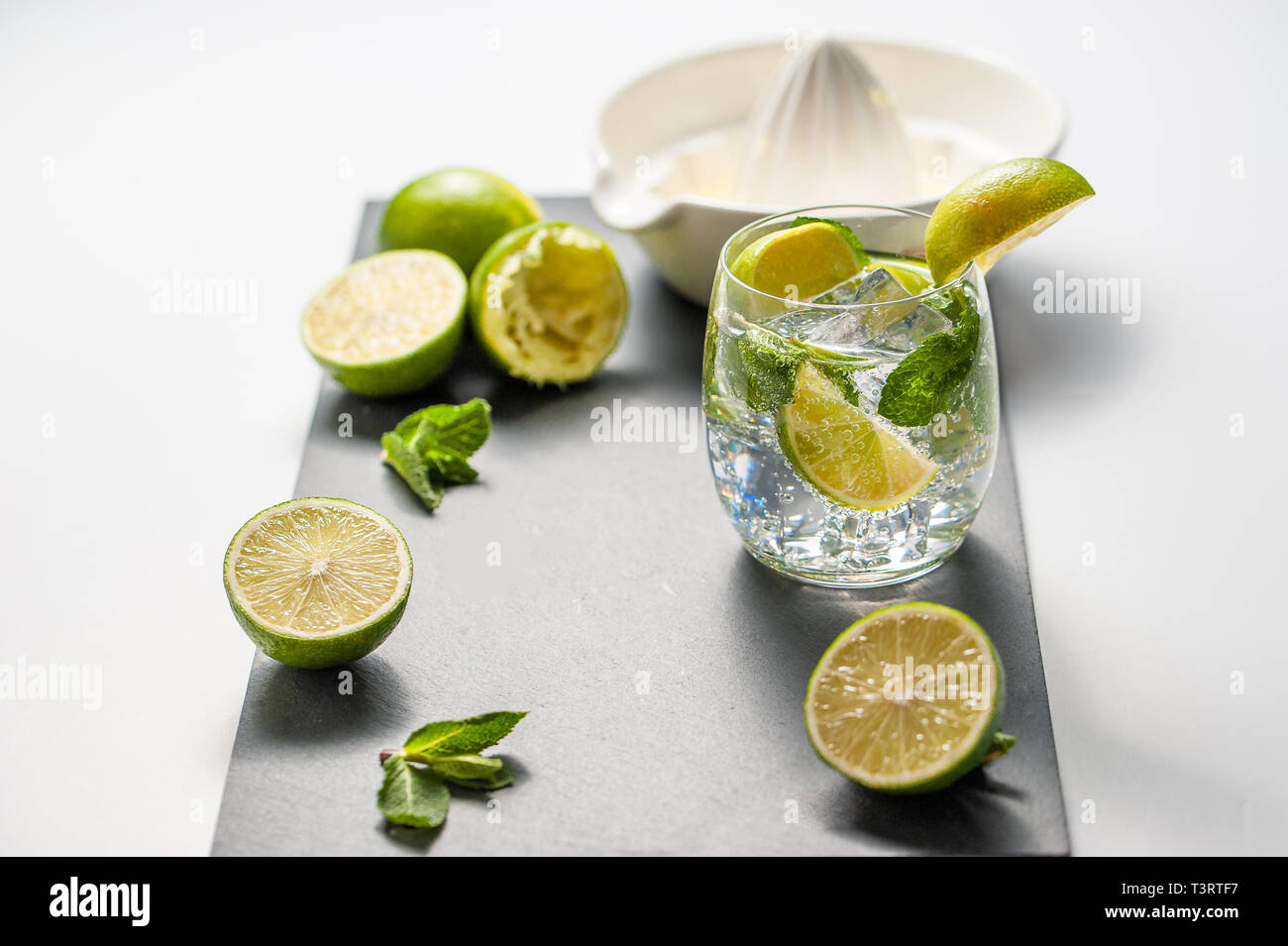 Sommer cocktail Konzept: frischen Mojito auf Schneidebrett mit grünem Limes Stockfoto