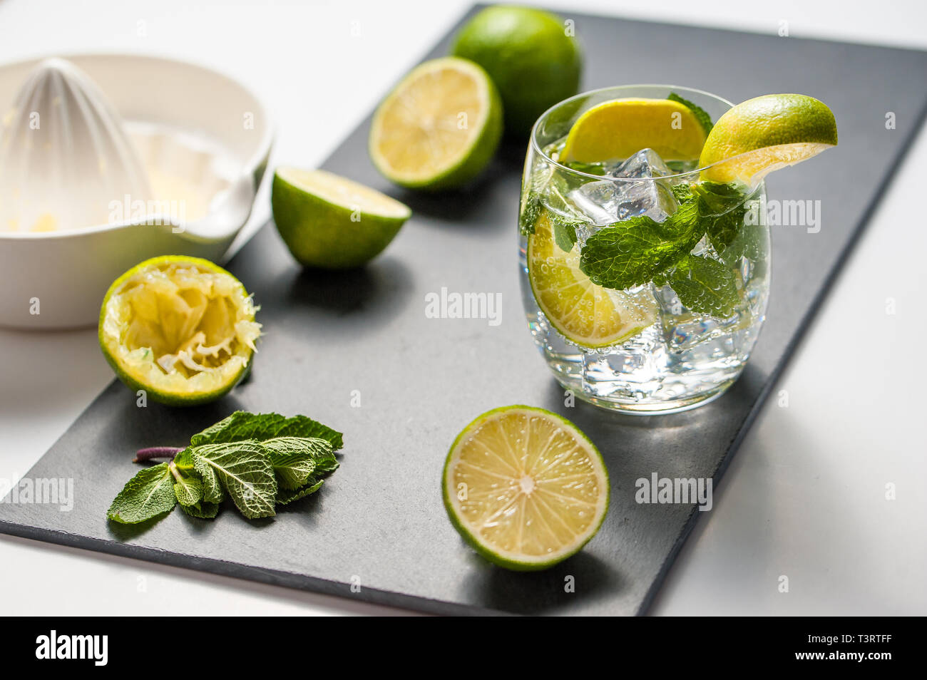 Sommer cocktail Konzept: frischen Mojito auf Schneidebrett mit grünem Limes Stockfoto