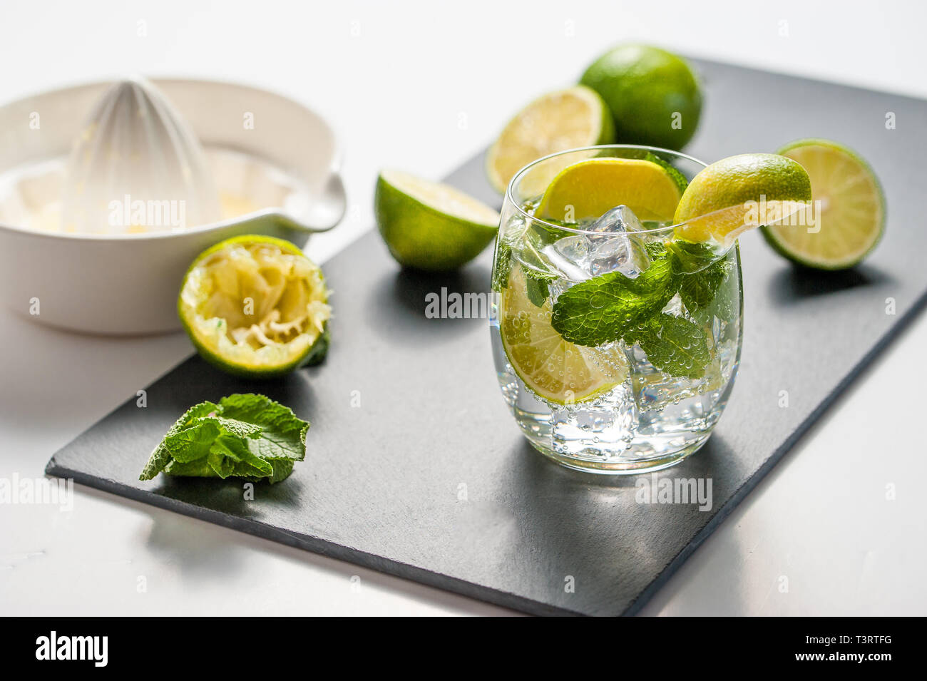 Sommer cocktail Konzept: frischen Mojito auf Schneidebrett mit grünem Limes Stockfoto