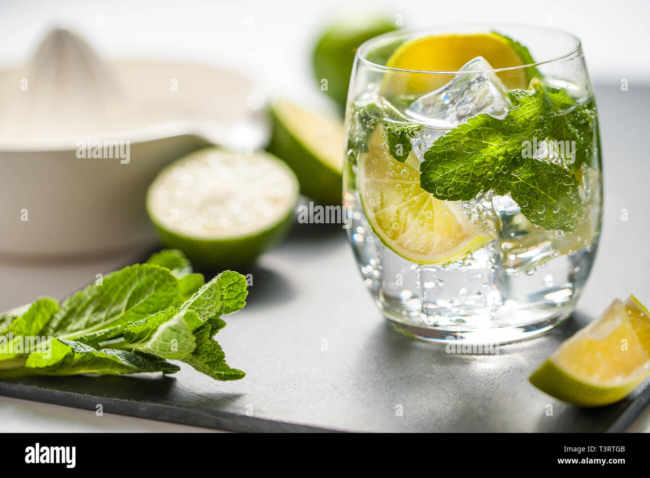 Sommer cocktail Konzept: frischen Mojito auf Schneidebrett mit grünem Limes Stockfoto