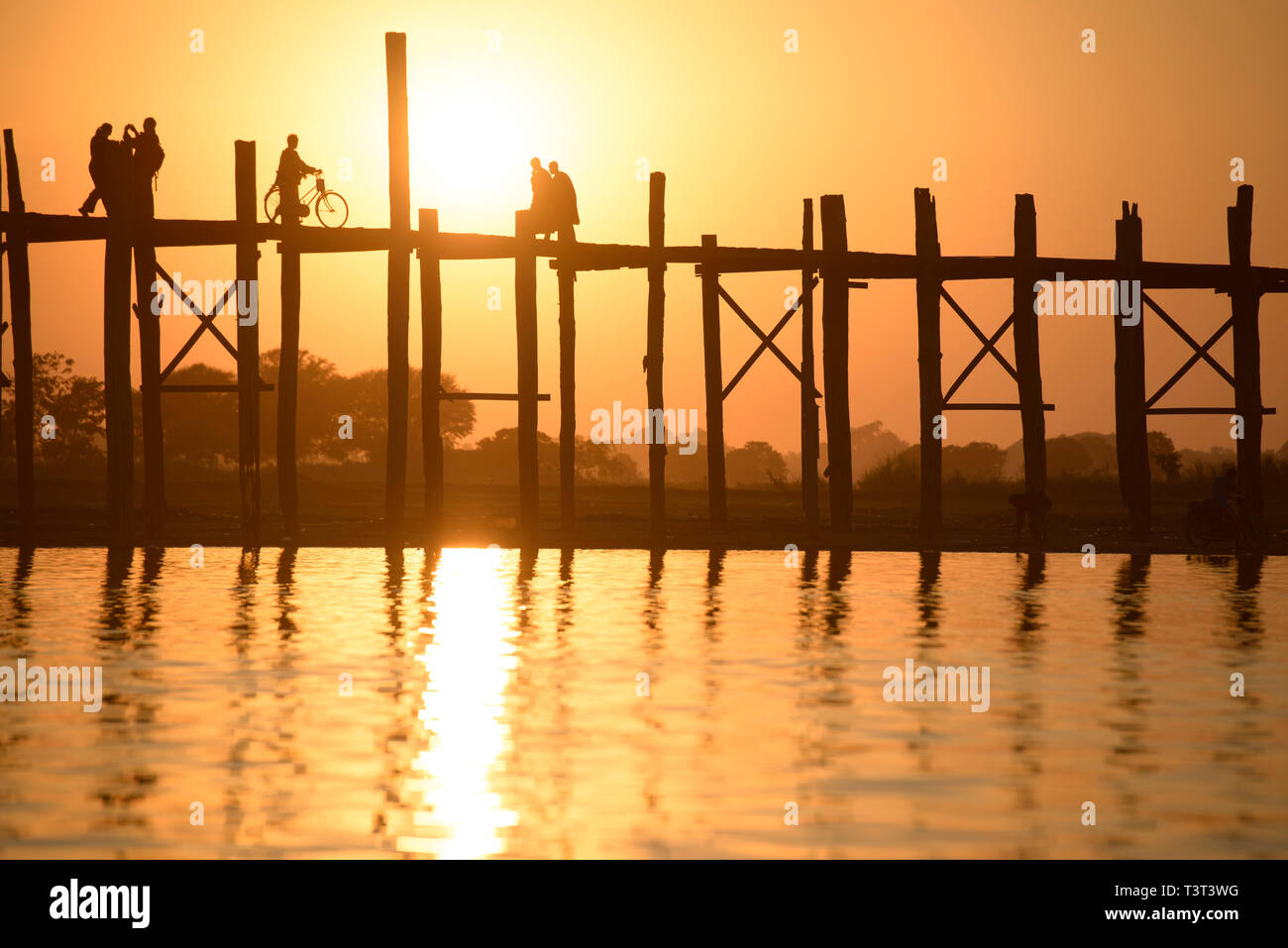 Menschen zu Fuß auf erhöhten Holzsteg bei Sonnenuntergang Stockfoto