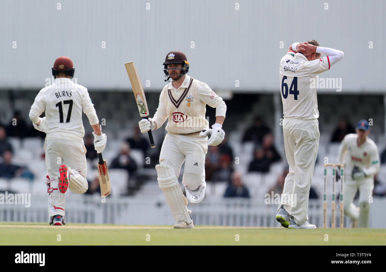 Die Surrey Rory Verbrennungen und Mark Stoneman machen einen Durchlauf als Essex Bowler Peter Siddle seine Hände auf seinen Kopf während des Tages eine der Specsavers County Championship, Abteilung eine Match am Kia Oval, London. Stockfoto