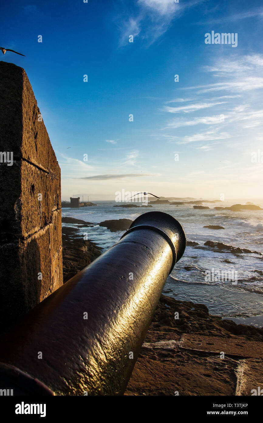 Die malerische Landschaft auf den Atlantischen Ozean bei Sonnenuntergang mit alten Metall Kanone im Vordergrund. Essaouira, Marokko Stockfoto