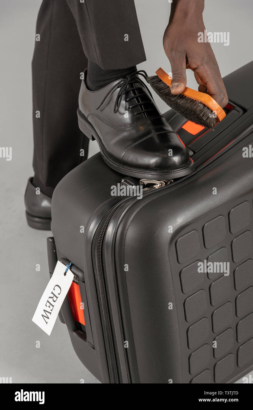 Airline Pilot Putzen seiner schwarzen Uniform Schuhen. Stockfoto